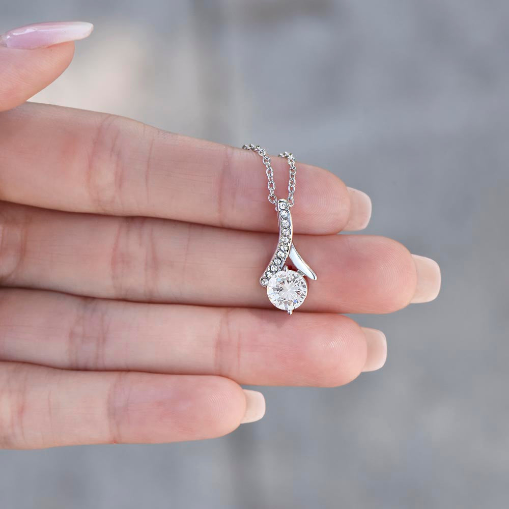 White gold Alluring Beauty necklace pendant held in a hand to show its size