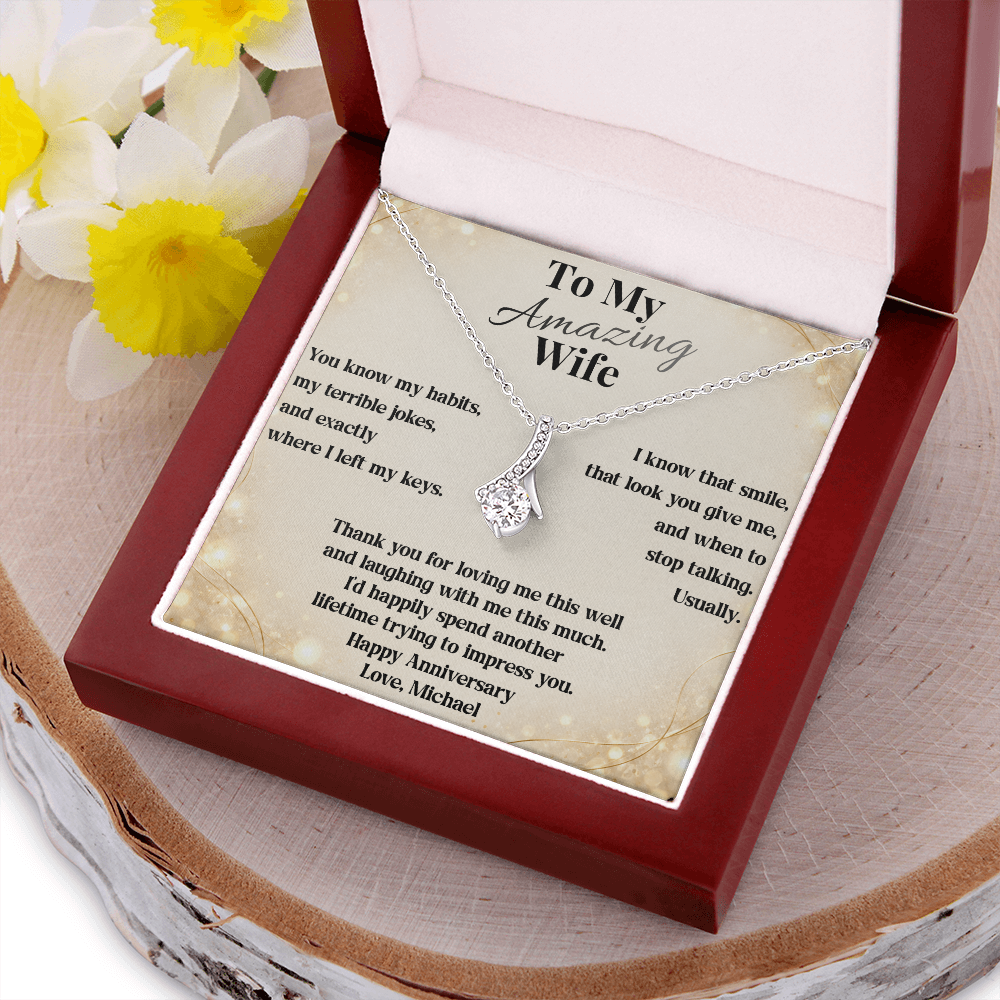 White gold anniversary necklace and wife message card in the luxury gift box beside flowers