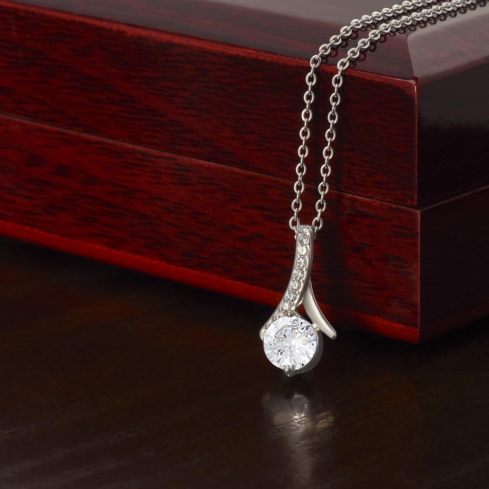 White gold Alluring Beauty necklace pendant beside a mahogany gift box