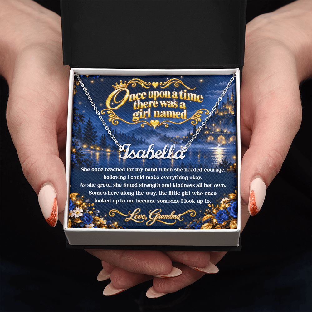 Hands presenting a silver-tone Isabella name necklace with a Once Upon a Time card from Grandma in an open black and white gift box.