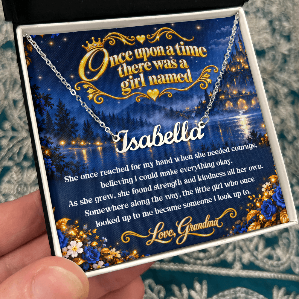 Hand holding a white gift box with a silver-tone Isabella name necklace and blue fairy-tale message card from Grandma.