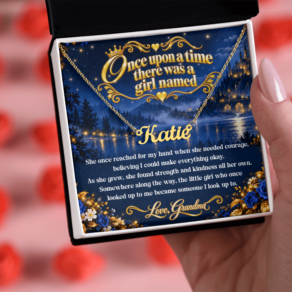 Gold-tone Katie name necklace and Once Upon a Time card from Grandma in an open black and white gift box, with red roses behind.