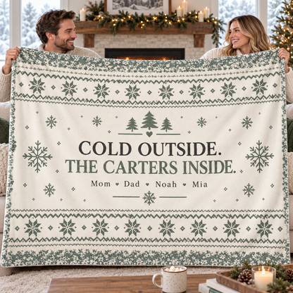 Two adults holding open a large 80 by 60 cream and sage personalized family fleece blanket with the sample Carter family design.